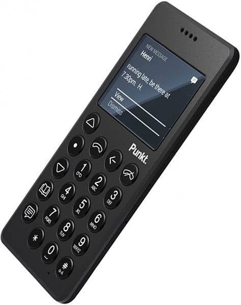 Front view of a black Punkt MP01 phone showing its small screen with a text message and numeric keypad.