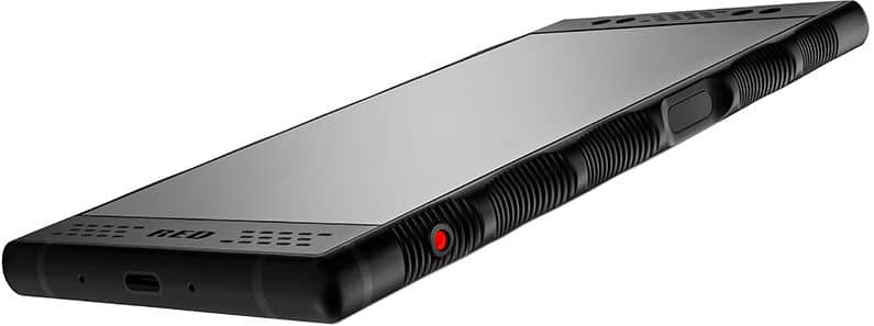 Red Hydrogen One black smartphone angled to show front and side, textured grip, red side button, speaker grilles, and USB-C port.