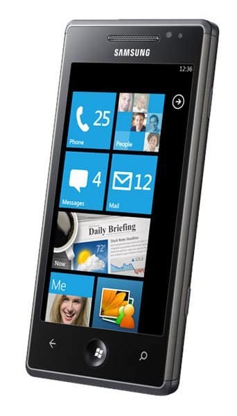 Samsung Omnia 7 front view displaying Windows Phone interface with blue tile menu showing phone, people, messages, mail, news, and profile icons