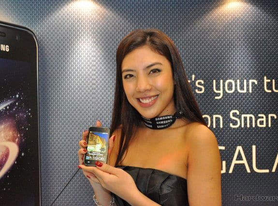 Woman holding Samsung Captivate smartphone displaying its screen at a product event