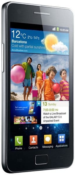 Front view of black Samsung Galaxy S II showing home screen with Barcelona weather, app icons, beach photo, and 10:20 AM time.