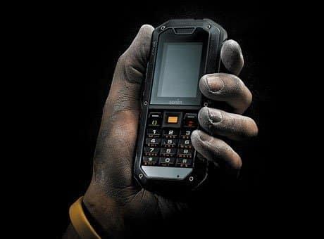 Sonim XP2.10 Spirit rugged phone held in hand, front view, showing small screen and numeric keypad against black background