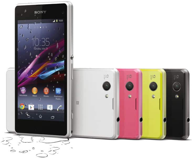 Sony Xperia Z1 Compact in white, pink, yellow, and black shown rear; front view upright displays water-droplet screen on wet surface.