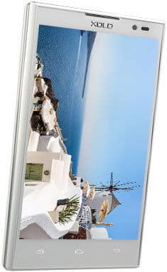 XOLO Q1001 smartphone, front view, displaying a scenic coastal landscape with white buildings and blue sky on screen